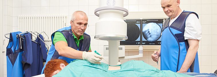 Zwei Ärzte behandeln eine Frau am Rücken